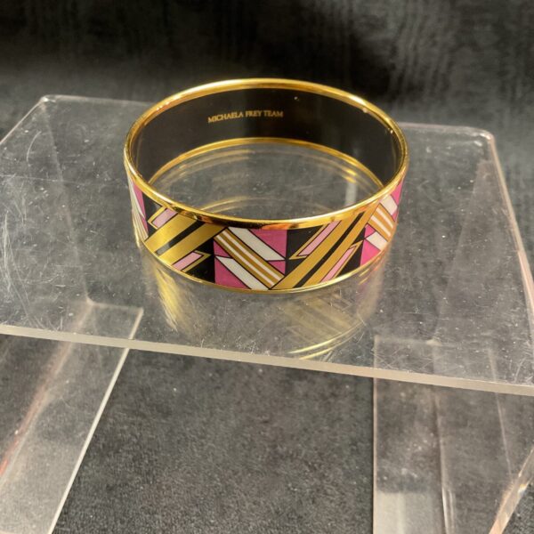 Michaela Frey Team 24 carat gold plated enamel bangle bracelet featuring a geometric pattern in pink black and white