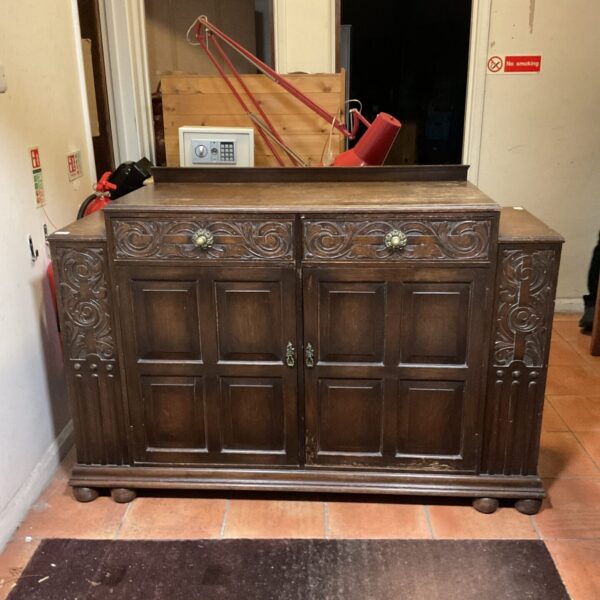 Large antique Jacobean oak sideboard in a hallway setting.