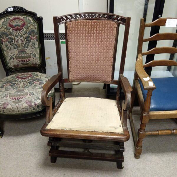 Antique James Schoolbred campaign chair with worn upholstery.