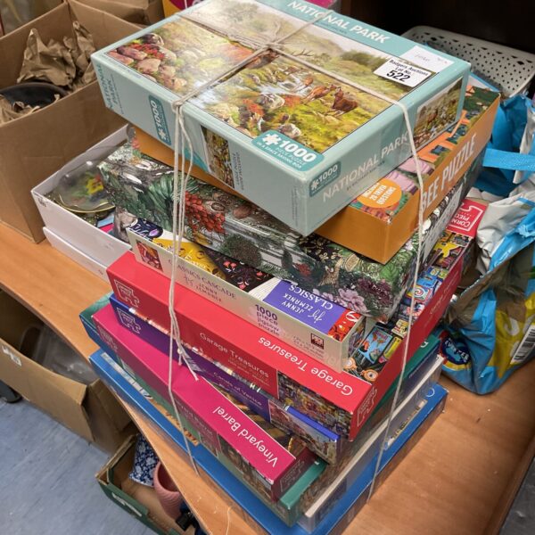 Mixed lot of jigsaw puzzles including Ravensburger and corner piece puzzles.