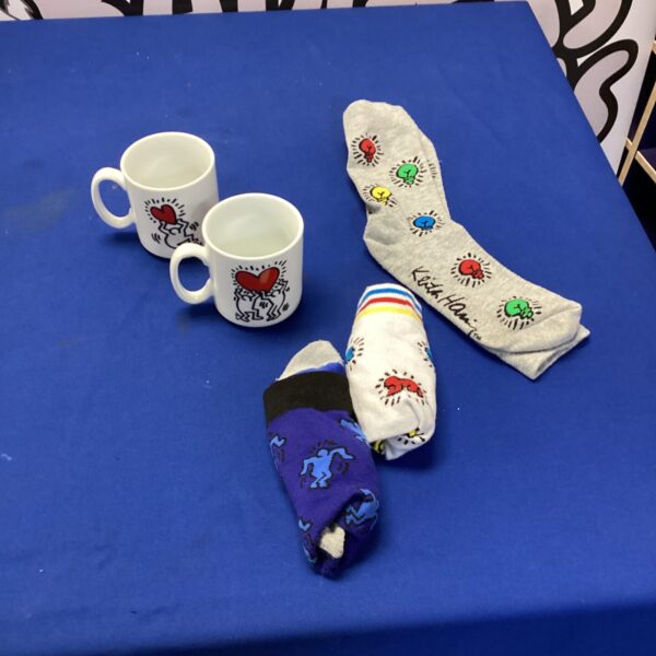 Keith Haring socks and mugs lot, colourful pop art collectibles.