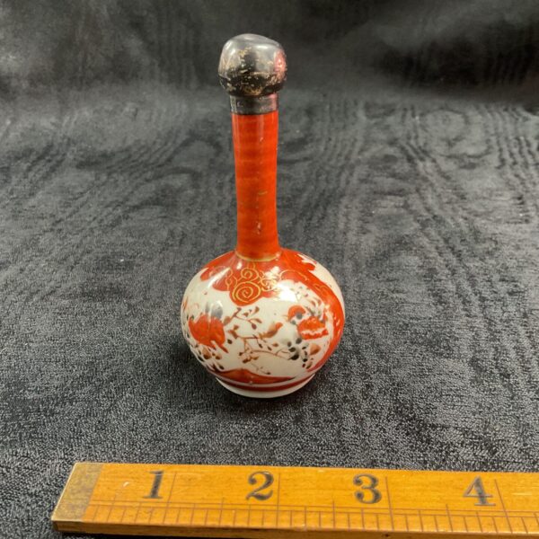 Antique Japanese Kutani perfume bottle with silver top, vibrant floral design.