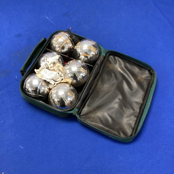 Green zippered pouch containing four lawn bowls for outdoor games.