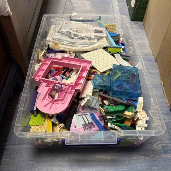 Large mixed lot of Lego bricks and manuals for building.