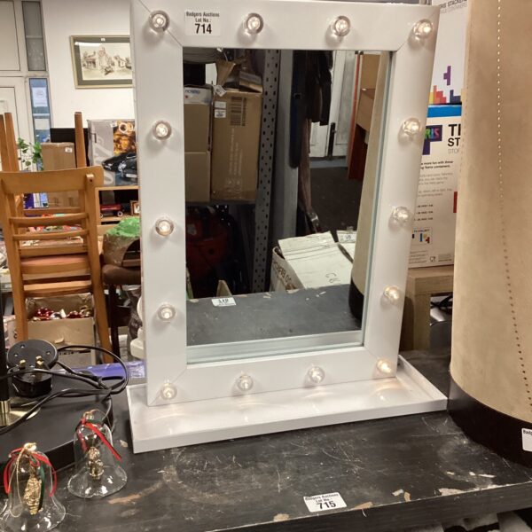 Illuminated light-up vanity mirror with surrounding lights.