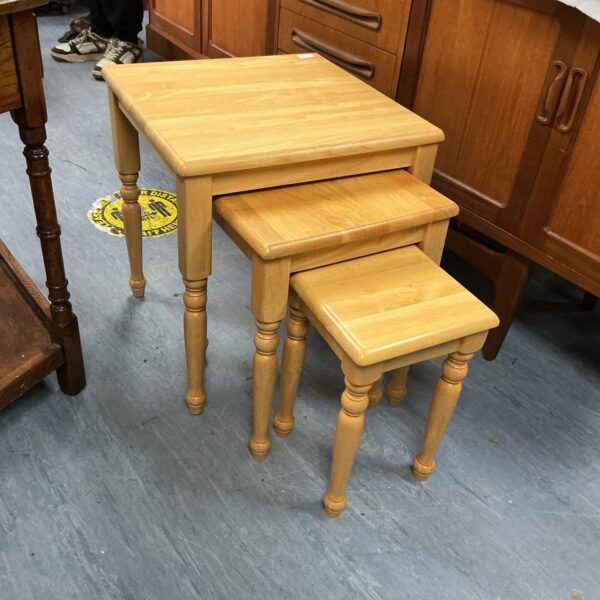 Vintage light wood nest of tables in a home setting.