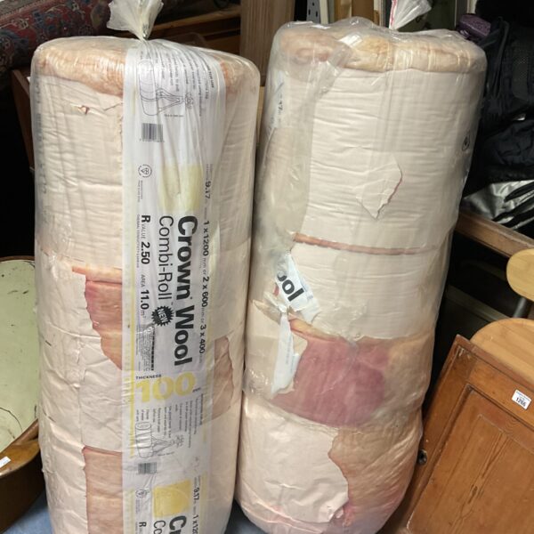 Two rolls of loft insulation stacked in a workshop.