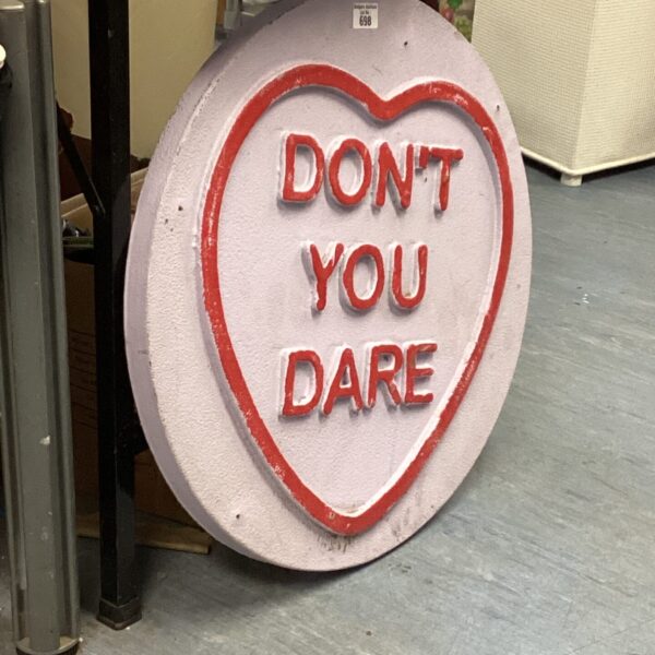 Large love heart decoration with “don’t you dare” text, vintage kitsch decor.