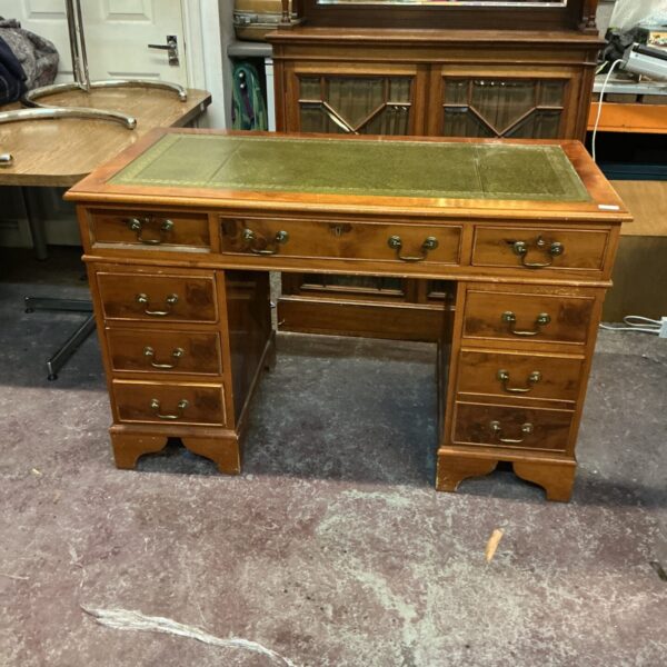 Antique mahogany desk with green leather writing surface.