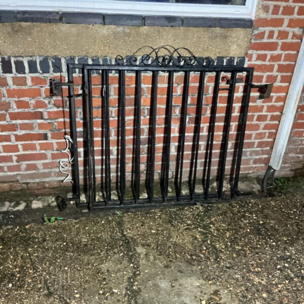Traditional metal garden gates showing signs of weathering.