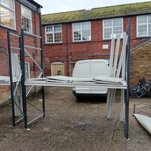 Grey metal racking system for storage in a workshop setting.