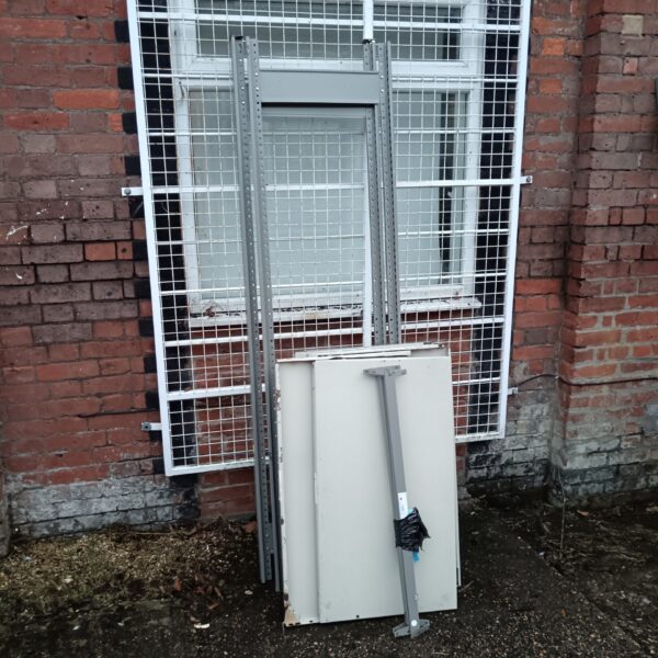 Used metal racking unit with shelves for storage.