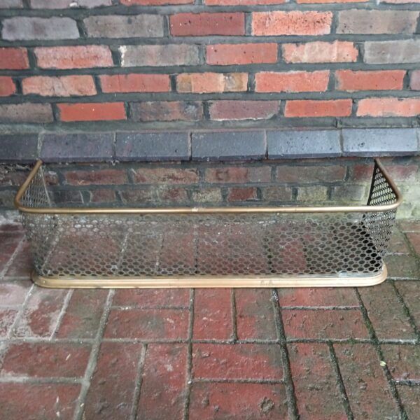 Vintage mid century brass fireplace fender with woven mesh.