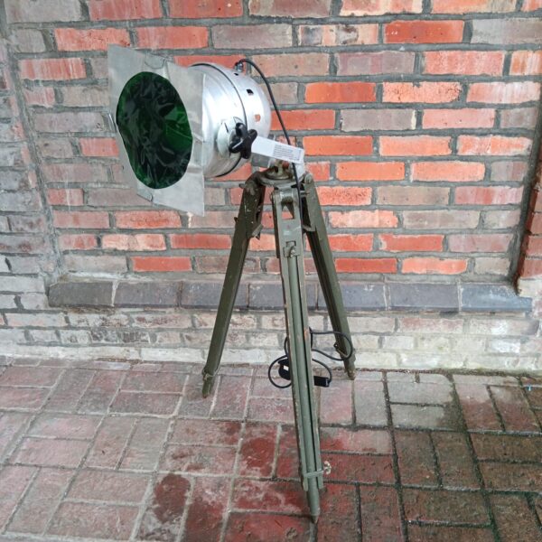 Vintage military spotlight on a steel tripod, ideal for collectors.