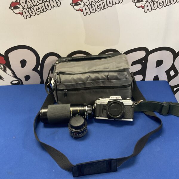 Vintage Minolta camera kit with multiple lenses for film photography.