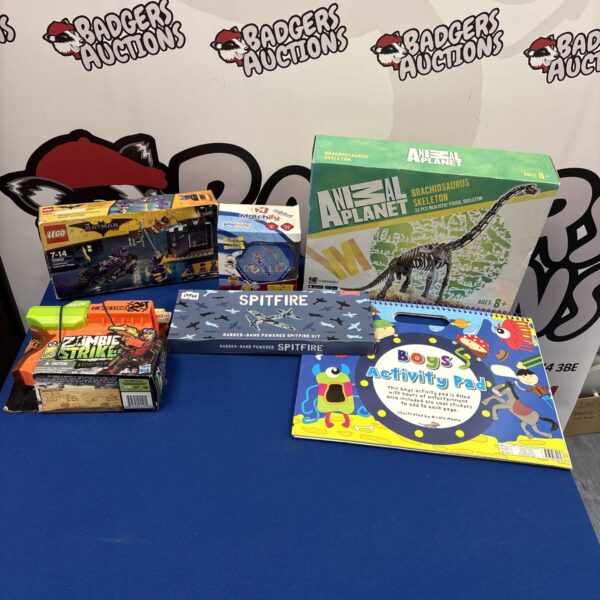 Mixed toy lot featuring sealed Lego Batman and dinosaur skeleton.