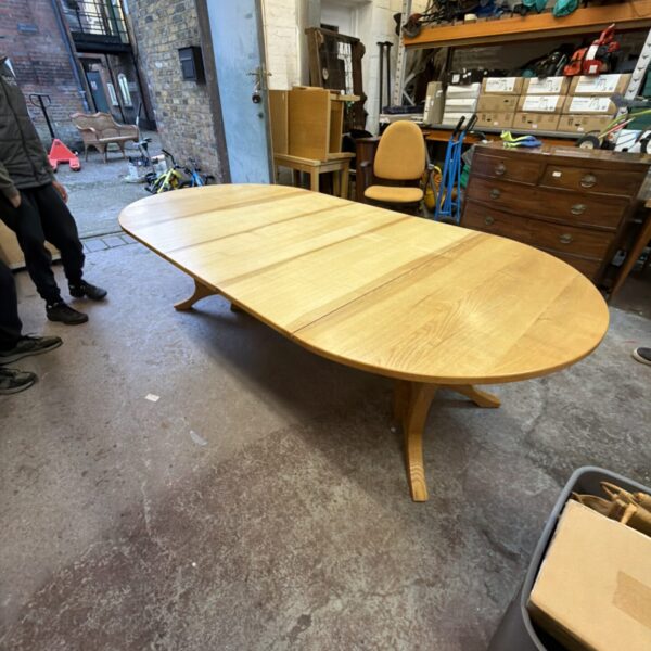 Large oak extendable dining table in a rustic setting.