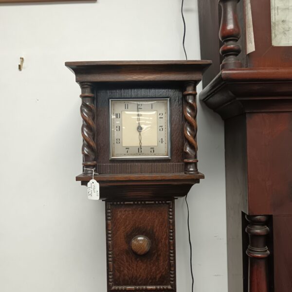 Vintage oak grandmother clock with Smiths movement in a hallway.