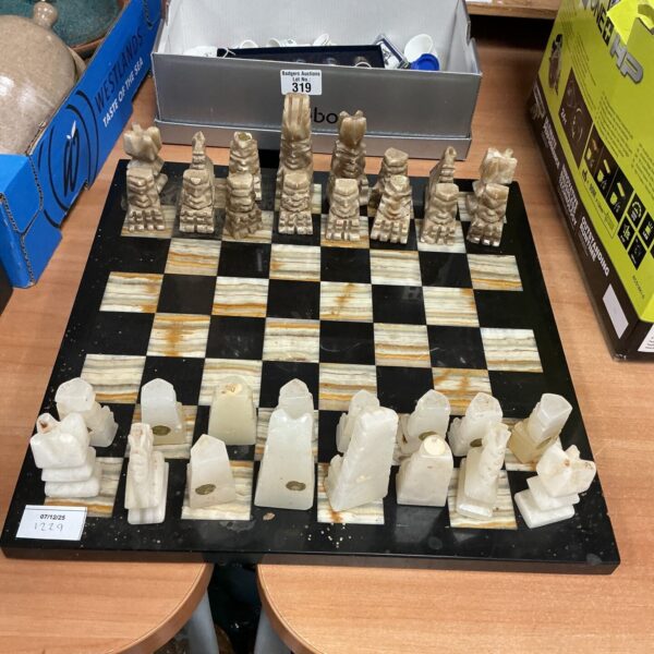 Elegant onyx and marble chess set with chessboard displayed.
