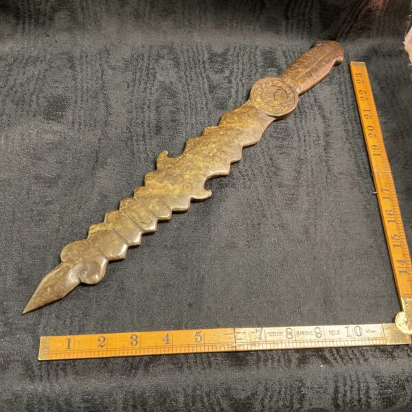 Intricately carved antique oriental stone dagger with detailed handle.