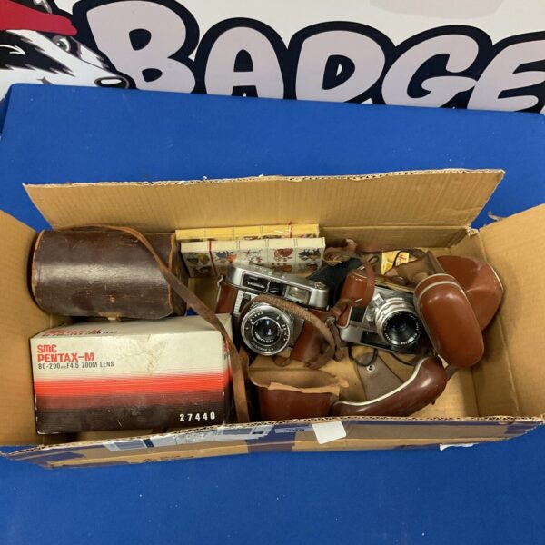 Vintage Pentax camera lot with zoom lens and accessories.