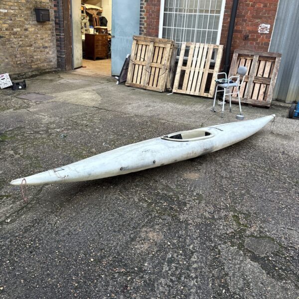 Side view of a red Perception one man kayak.