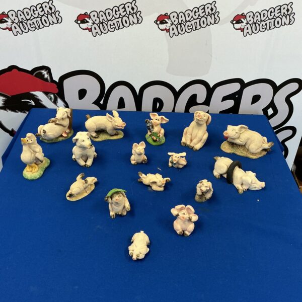 Collection of vintage porcelain pig figurines on a dark surface.