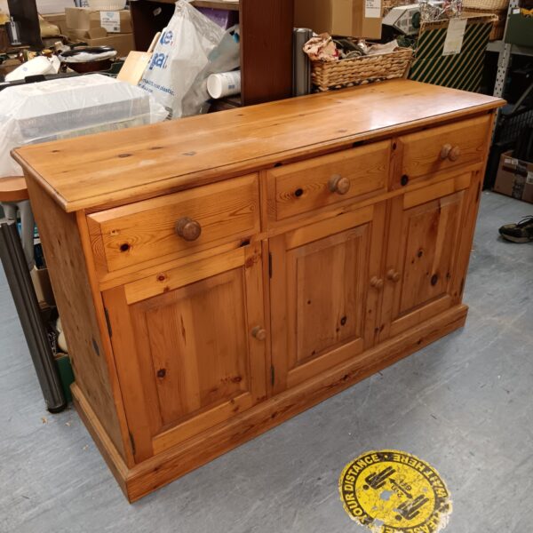 Rustic pine sideboard with drawers, ideal for farmhouse kitchens.