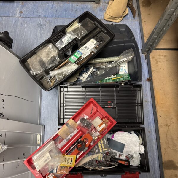 Mixed lot of plastic toolboxes filled with tools and hardware.