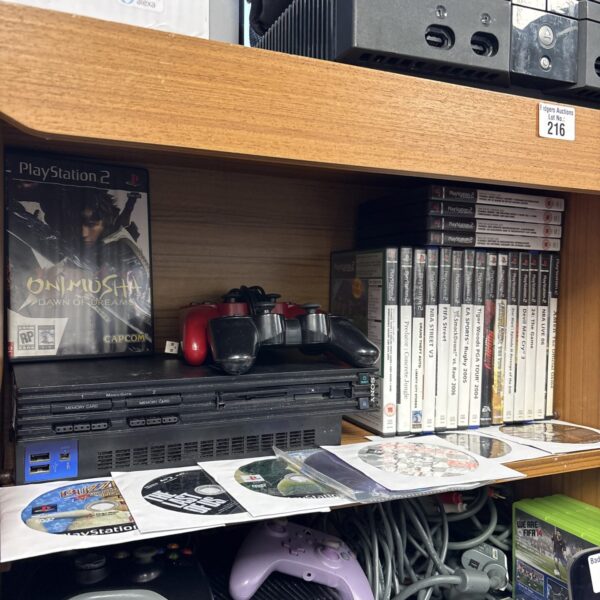 Sony PlayStation 2 console with games and controllers for retro gaming.