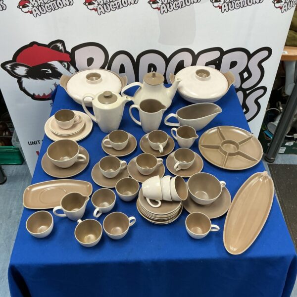 Large collection of vintage Poole Pottery tableware on display.