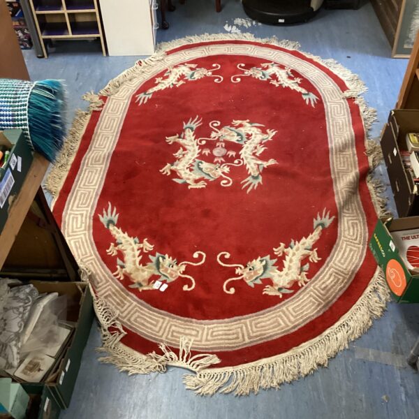 Red oriental rug with a detailed dragon pattern, vintage style.