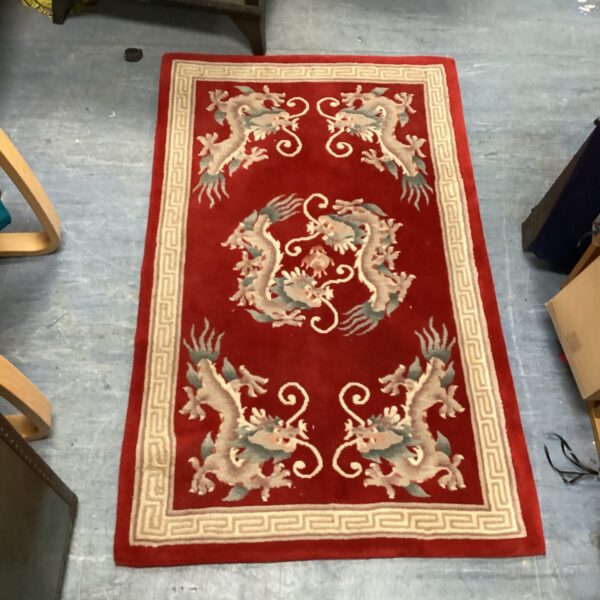 Vibrant red Oriental rug with detailed dragon pattern.