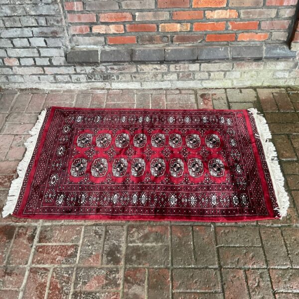 Detailed view of a red Persian rug with floral patterns.