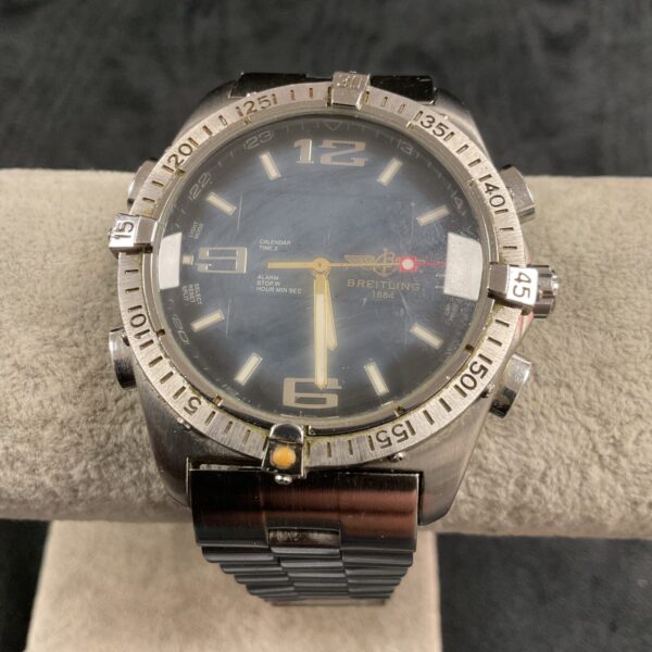 Black and steel replica quartz wristwatch with rotating bezel.