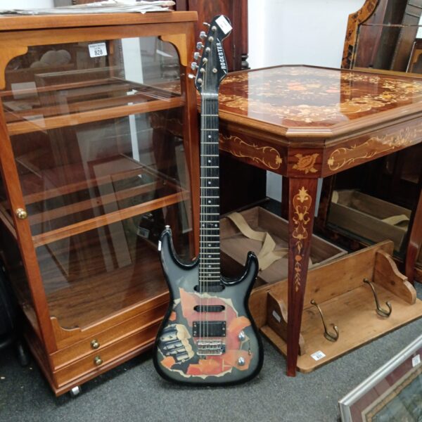 Black Rockster electric guitar with red and yellow detailing.