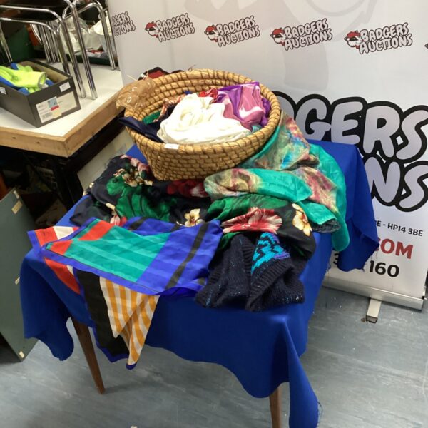 Assorted silk scarves and handkerchiefs in a woven basket.