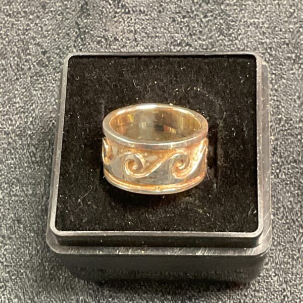 Close-up of a silver and gold ring, size L.