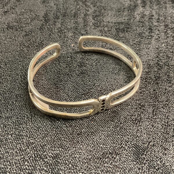 Modern silver bracelet with geometric openwork design.