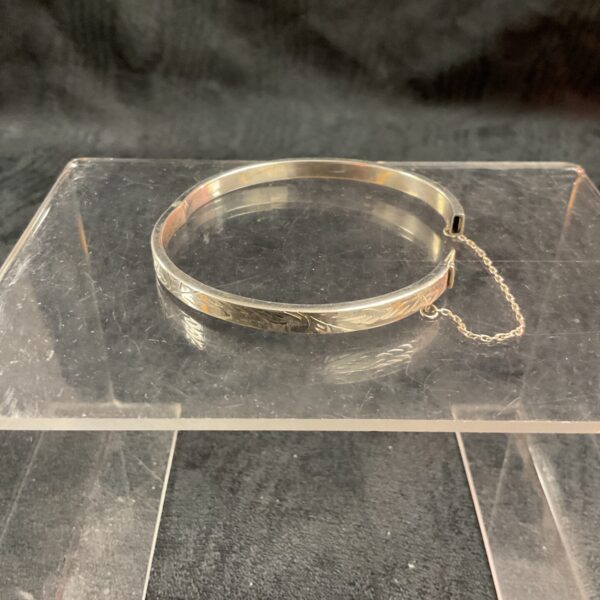 Detailed view of vintage silver hinged bracelet with decorative design.