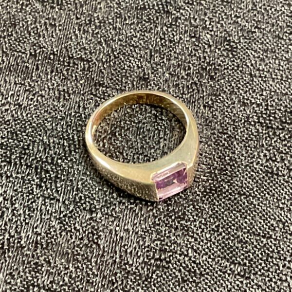 Close-up of silver ring with rectangular moonstone gemstone.