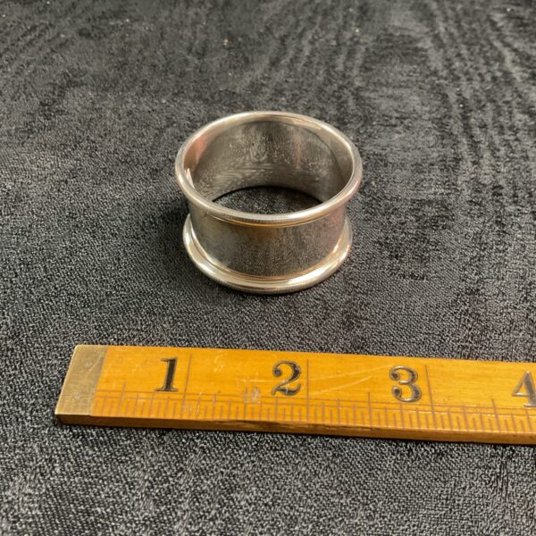 Hallmarked silver napkin ring displayed with a ruler for scale.