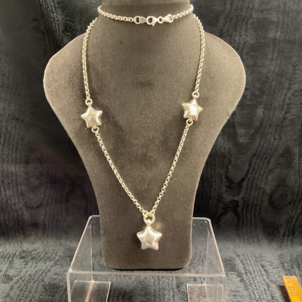 Delicate silver star pendant necklace on a chain.