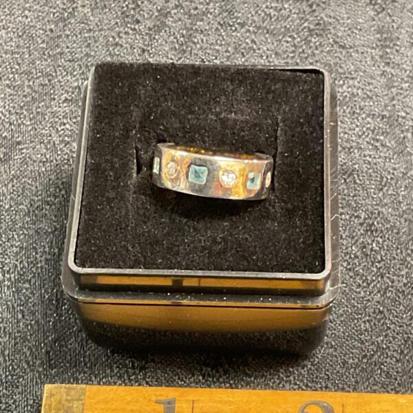 Close-up of a silver ring with a vibrant topaz gemstone.