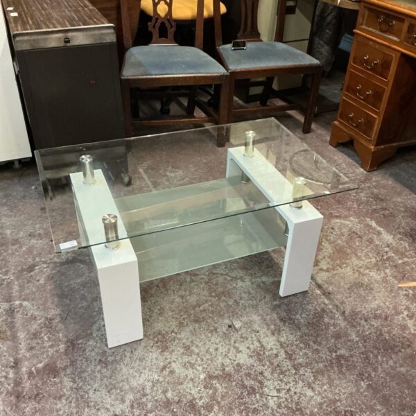 Modern small glass coffee table with white base.