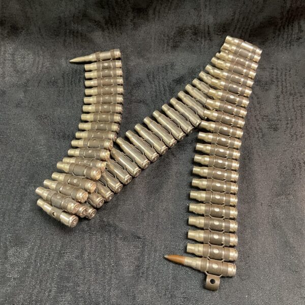 Close-up of a spent ammunition belt with linked bullet casings.