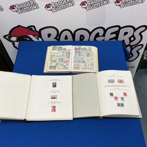 Front view of three vintage stamp albums with contents.