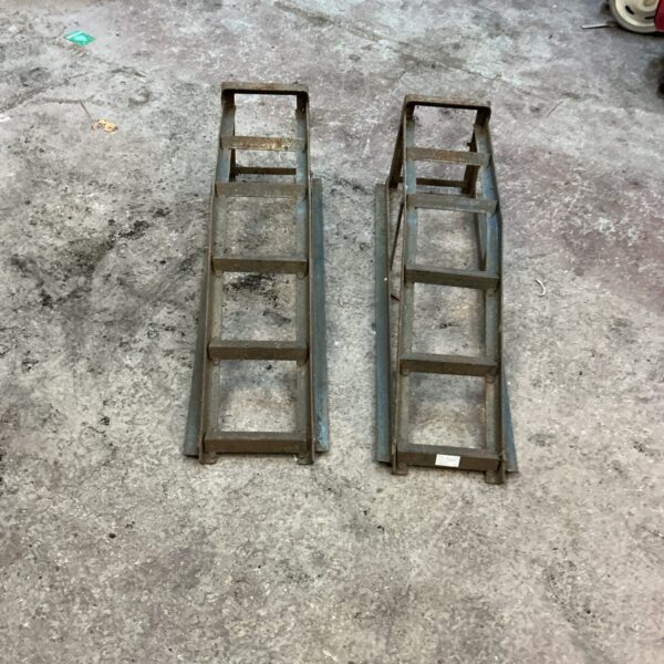Pair of used steel car ramps for vehicle maintenance.