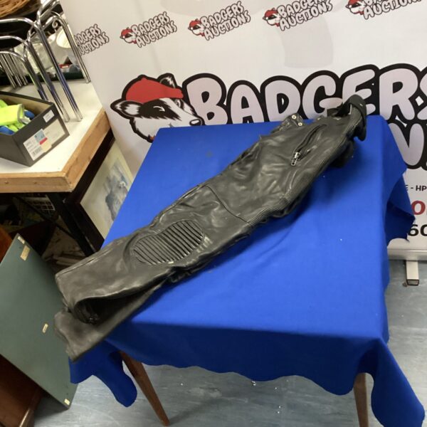 Stein leather motorcycle trousers displayed on a table.