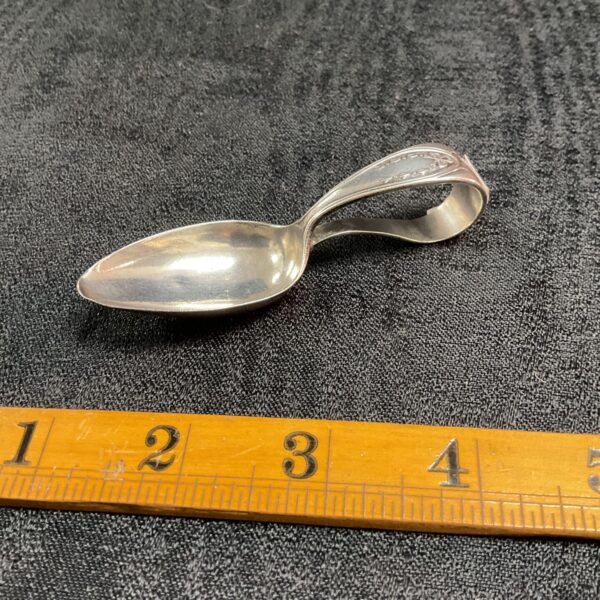Antique sterling silver baby spoon with ruler for scale.